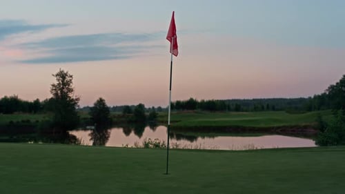 Red Flag Waving in Breeze on Golf Course