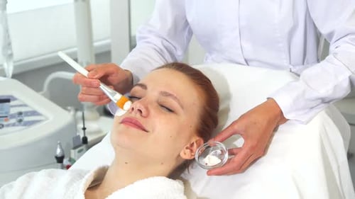 Woman Receiving Facial Treatment in Spa Setting