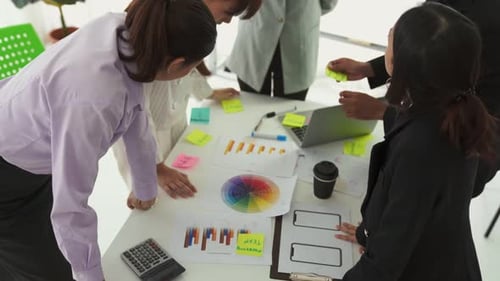 Business People Proficiently Discuss Work Project on Meeting Table