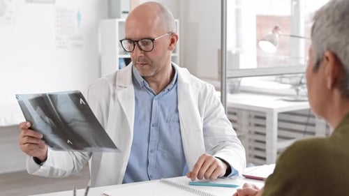 Doctor Discusses X-ray with Patient in Clinic