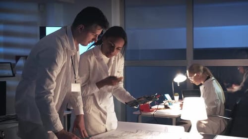 Technologieforschungslabor: Elektronikingenieure gemischter Rassen in weißen Kitteln arbeiten mit