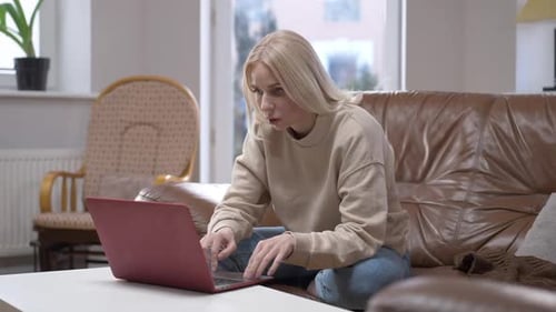 Woman Types on Laptop in Home Setting