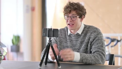 Young Adult Vlogging on Phone in Office