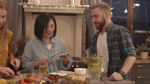 Friends Preparing Food Together at Home at Night
