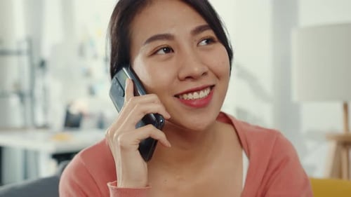 Young Woman Chatting on Smartphone at Home