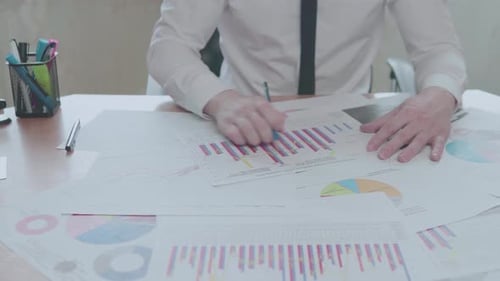 Businessman analyzes graphics while sitting in an office at a desk