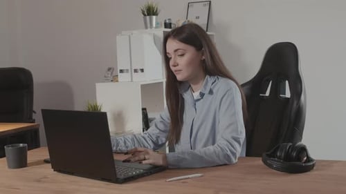 Girl in a Modern Office Working on a Laptop