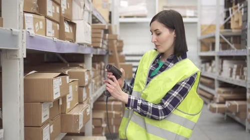 Store Worker Using Bar Code Scanner Scanning Labels on Boxes