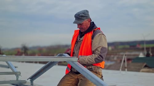 Arbeiter befestigt Metallbasis für Sonnenkollektoren
