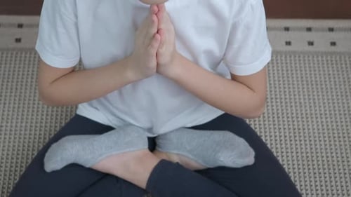Thoughtful Child Meditating Calmly on a Rug Indoors
