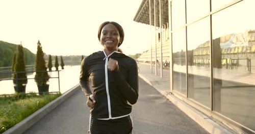 Smiling Woman Runs Toward Camera at Sunrise