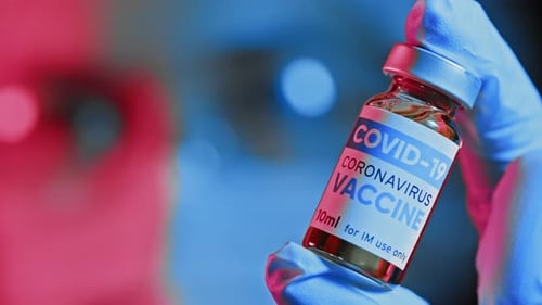 Doctor Holds an Ampoule with Medicine in Hands and Looks at It