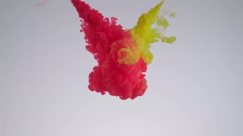 Red and Yellow Ink Dropping into Water