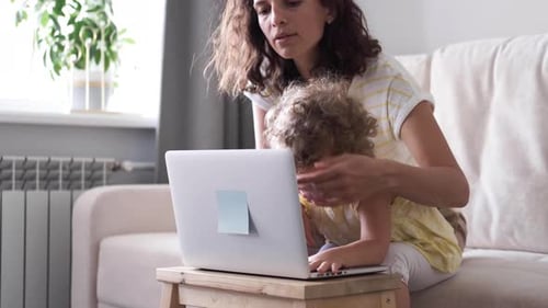 Mother and Child Use Laptop Together at Home