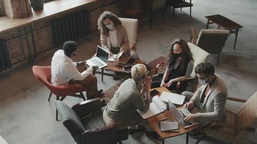 Coworkers in Face Masks Brainstorming in Loft Workspace