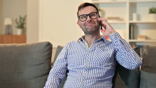 Man Smiling and Talking on Phone on Couch