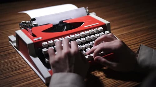 Hands Type on Red Vintage Manual Typewriter