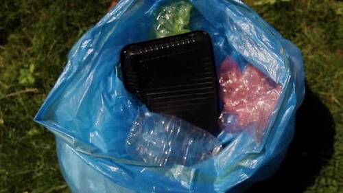Jóvenes familias reciclan botellas de plástico voluntarios dándose la mano mientras limpian en Green Park on a