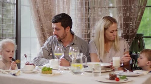 Couple with Kids Eating in Restaurant