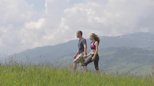 Couple Walks Hand-in-Hand Through Beautiful Grassy Field
