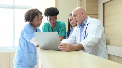 Medical Team Collaborating on Laptop in Hospital