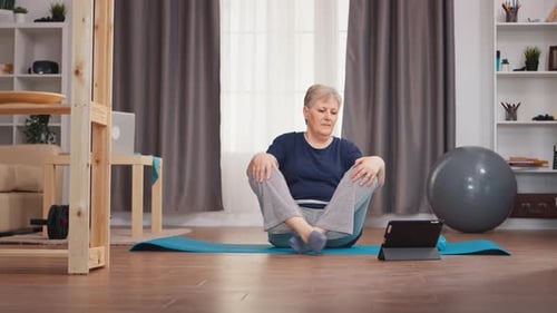 Senior Woman Stretching with Tablet at Home