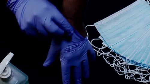 Putting on Surgical Gloves Beside Masks and Sanitizer