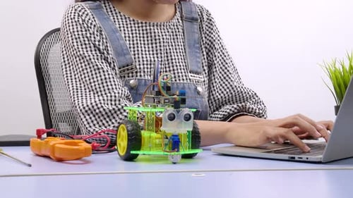 Robotikingenieure oder Student schreiben Programm auf Laptop für Roboterarm