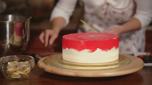 Close Up Shot of Cake That Spins on a Wooden Tray the Cook Colorizes the Dessert