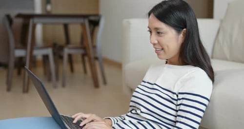 Young Woman Works on Laptop at Home
