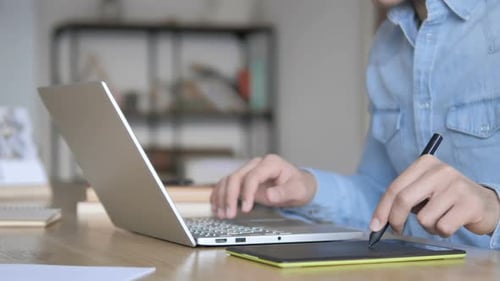 Person Using Graphics Tablet and Laptop