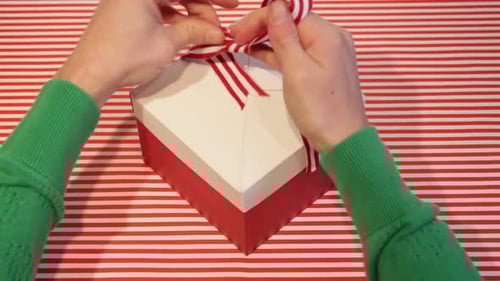 Hands Tie Ribbon on Christmas Gift Box