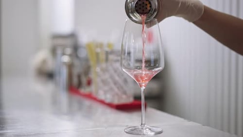 Bartender Pouring Red Cocktail into Wine Glass