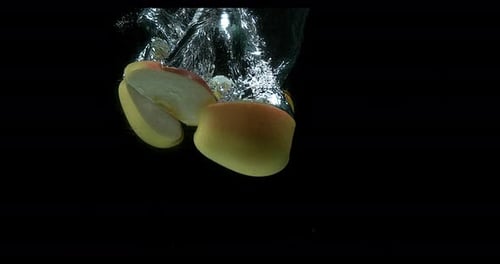 Apples, malus domestica, Fruit entering Water against Black Background, Slow Motion 4K