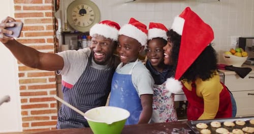Cheerful Family Taking a Christmas Selfie in Kitchen