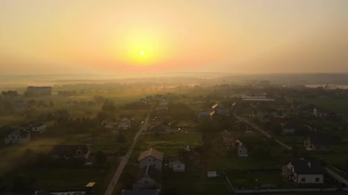 Aerial View Foggy Sunrise Over Residential Houses in Suburban Rural Area