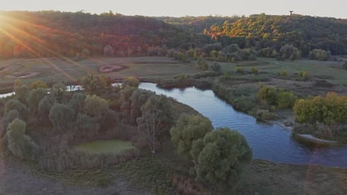 Scenic View of Curvy River Among Meadows at Sunset in Autumn
