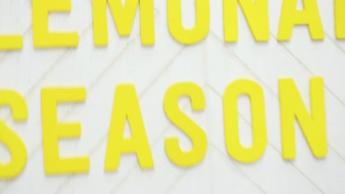 Hands Arrange Decorative "Lemonade Season" Sign