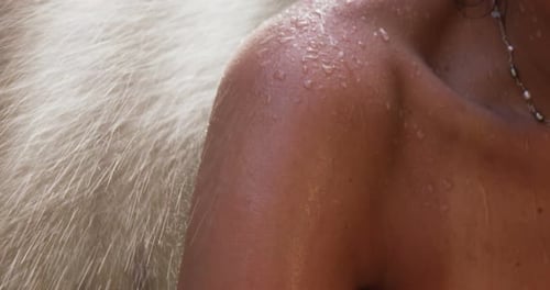 Woman's Wet Shoulder Next to White Dog in Shower