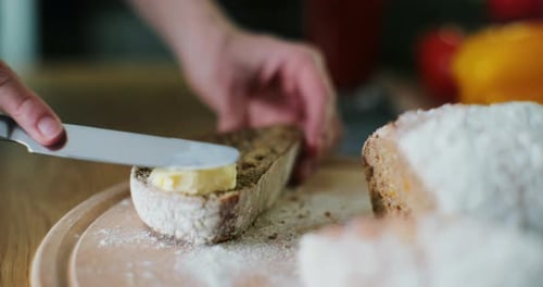Spreading Butter on Rustic Bread Slice Close Up