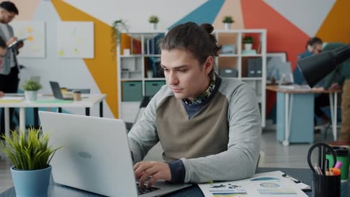 Slow Motion of Young Man Enjoying Successful Work Results Looking at Laptop Screen in Office