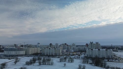 Flying in a suburban park. City blocks are visible. Winter cityscape.