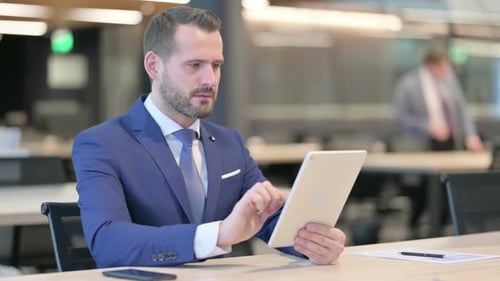 Distressed Man Reacts to Tablet in Office