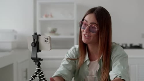 Woman Records Video on Smartphone in Modern Kitchen