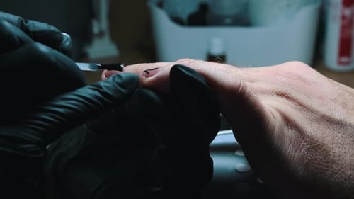 Manicure - Master Applying a Top Coat of Clear Nail Polish on Top of the Black Design - Male