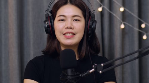 Young Woman Recording a Podcast with Microphone and Headphones