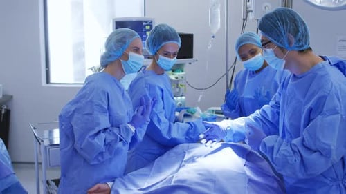 Diverse surgeons wearing surgical caps and face masks in operating theatre