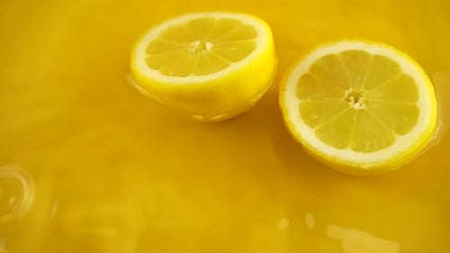 Lemon Halves Floating in Yellow Liquid