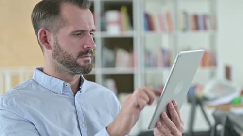 Man Looking at Tablet Getting Upset