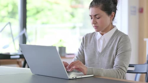 Woman Types on Laptop and Experiences Back Pain